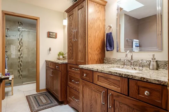 a bathroom with a granite countertop sink and a mirror