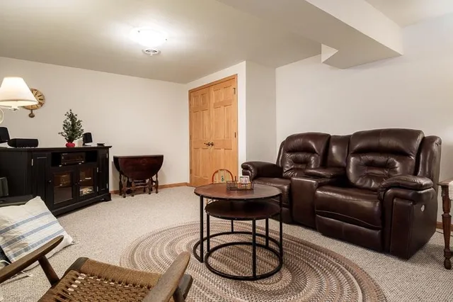 a living room with furniture a rug and a window
