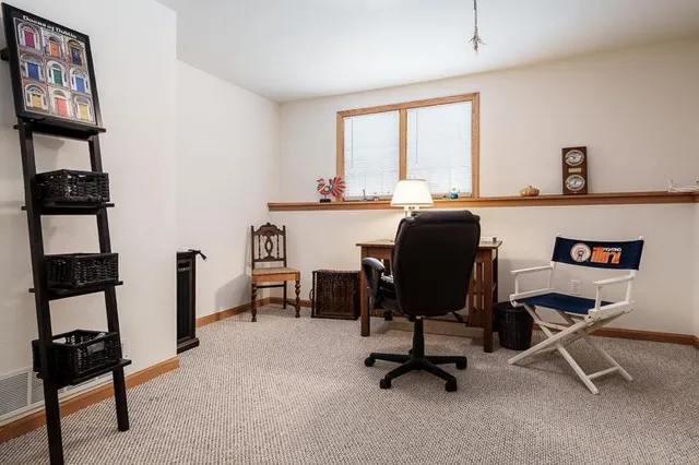 a view of a workspace with furniture and a window