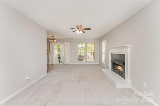 an empty room with windows and fireplace