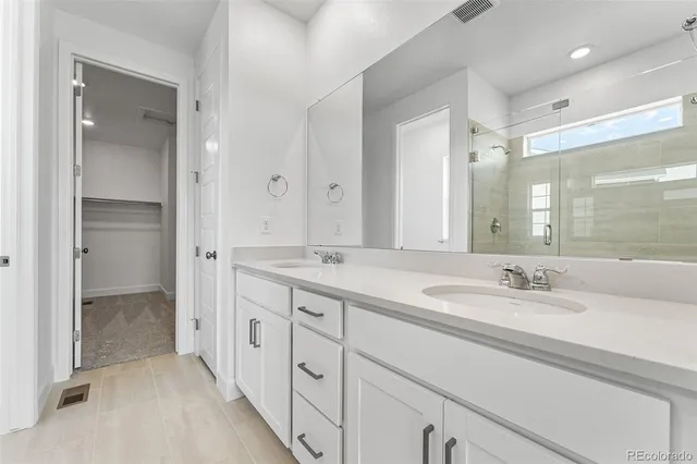 a spacious bathroom with a shower sink and mirror