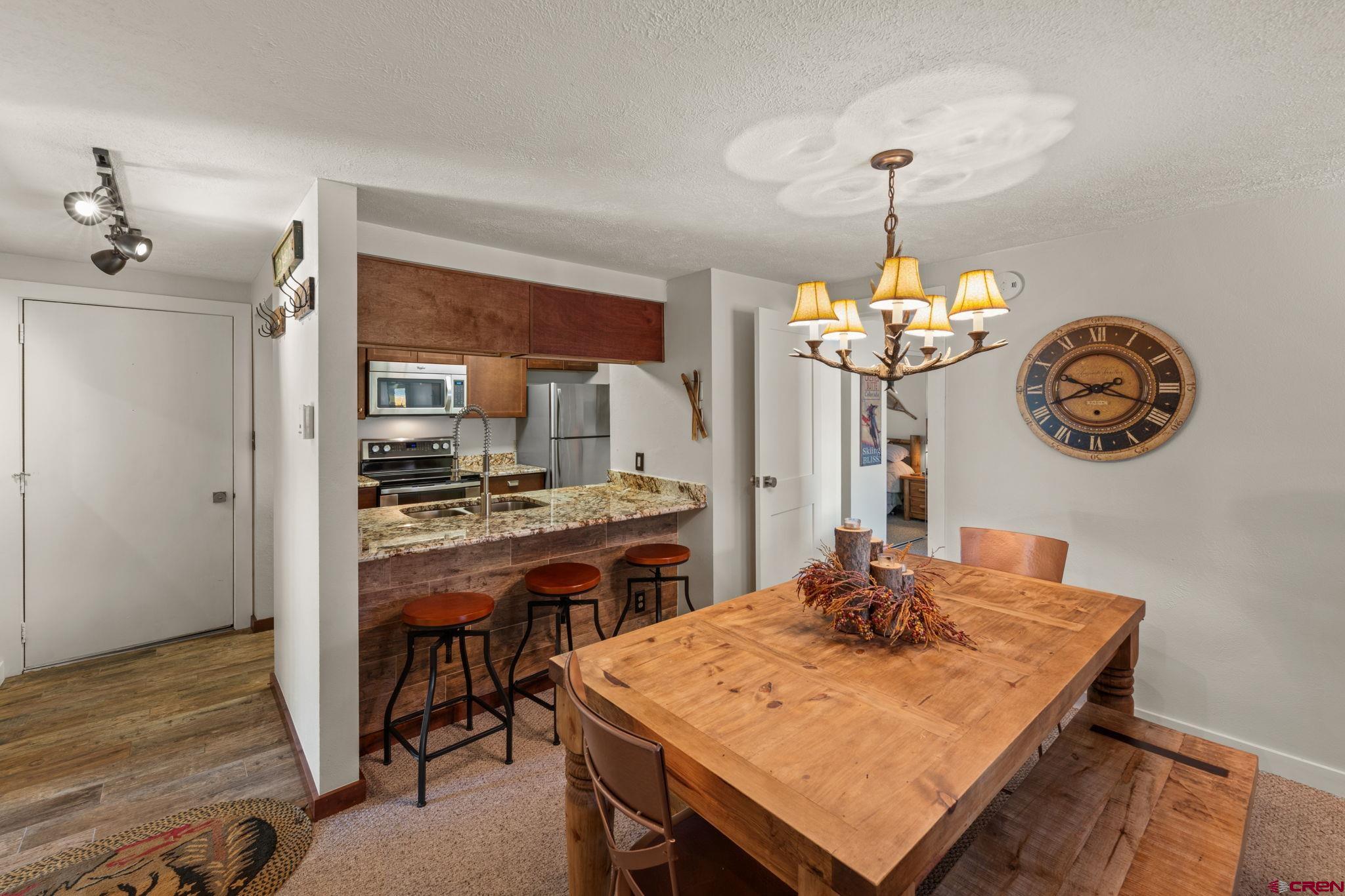 651 Gothic Road, Unit 502 Crested Butte, CO 81225 - Photo 12 of 44 a view of a dining room with furniture a chandelier and wooden floor