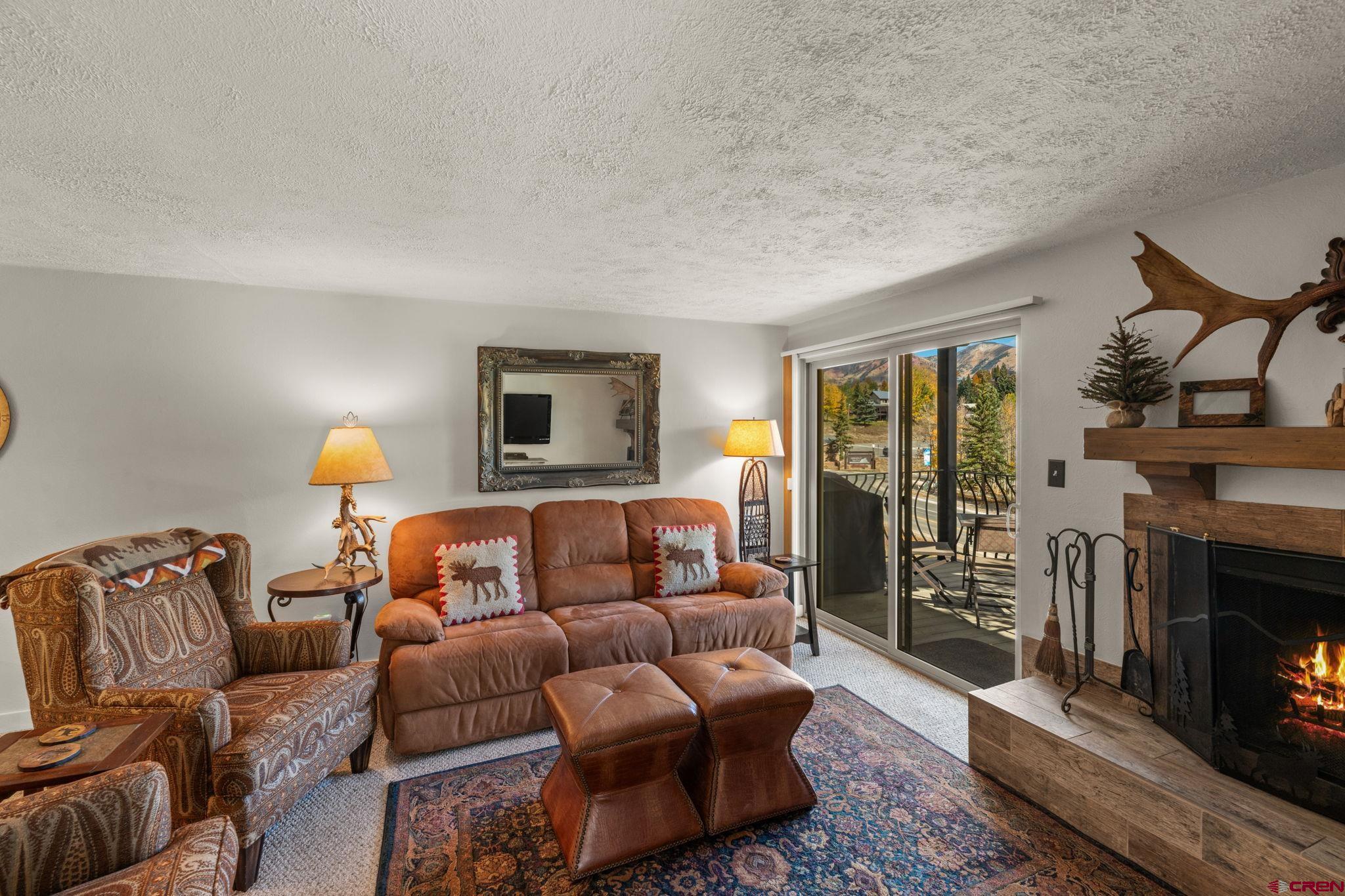 651 Gothic Road, Unit 502 Crested Butte, CO 81225 - Photo 20 of 44 a living room with furniture a fireplace and a flat screen tv