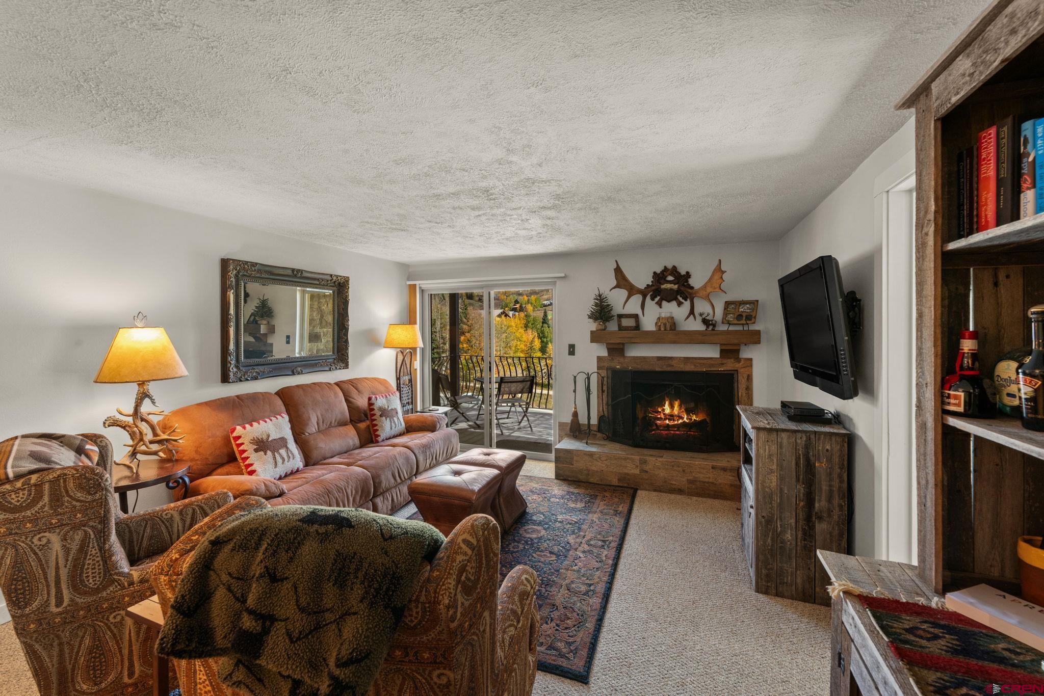 651 Gothic Road, Unit 502 Crested Butte, CO 81225 - Photo 21 of 44 a living room with furniture a fireplace and a flat screen tv