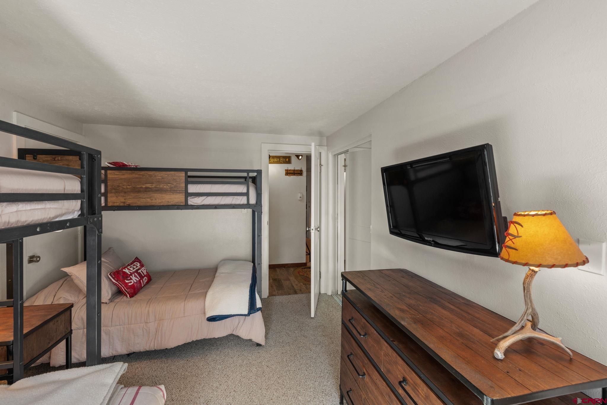 651 Gothic Road, Unit 502 Crested Butte, CO 81225 - Photo 25 of 44 a bedroom with a bed and flat screen tv