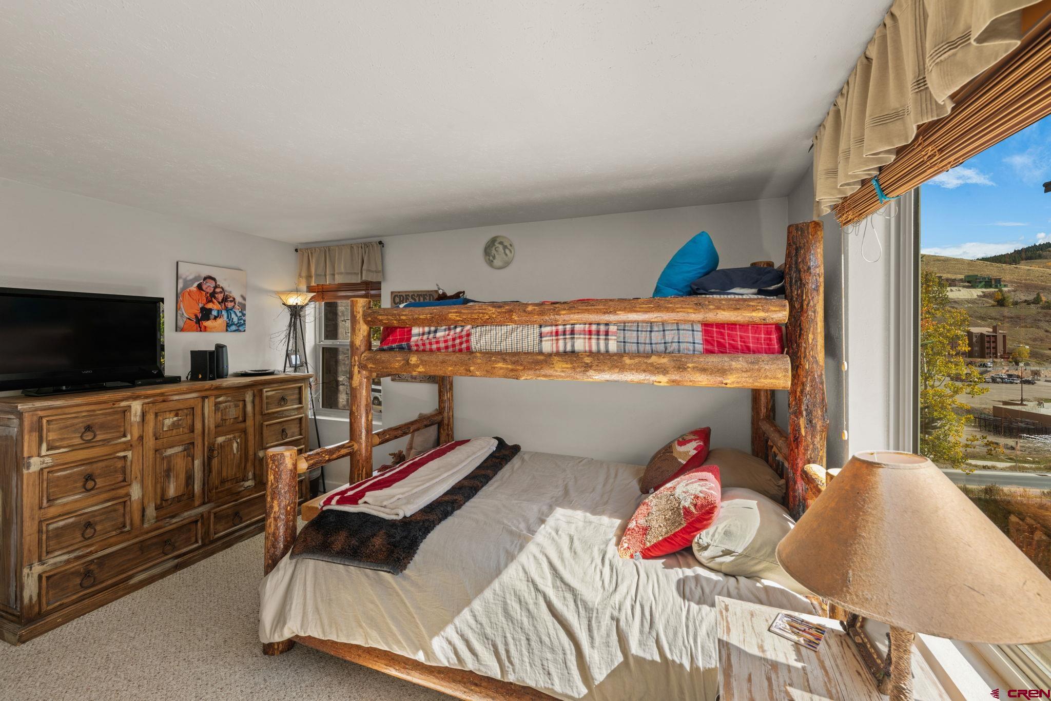 651 Gothic Road, Unit 502 Crested Butte, CO 81225 - Photo 31 of 44 a bed room with a bed furniture and a flat tv screen