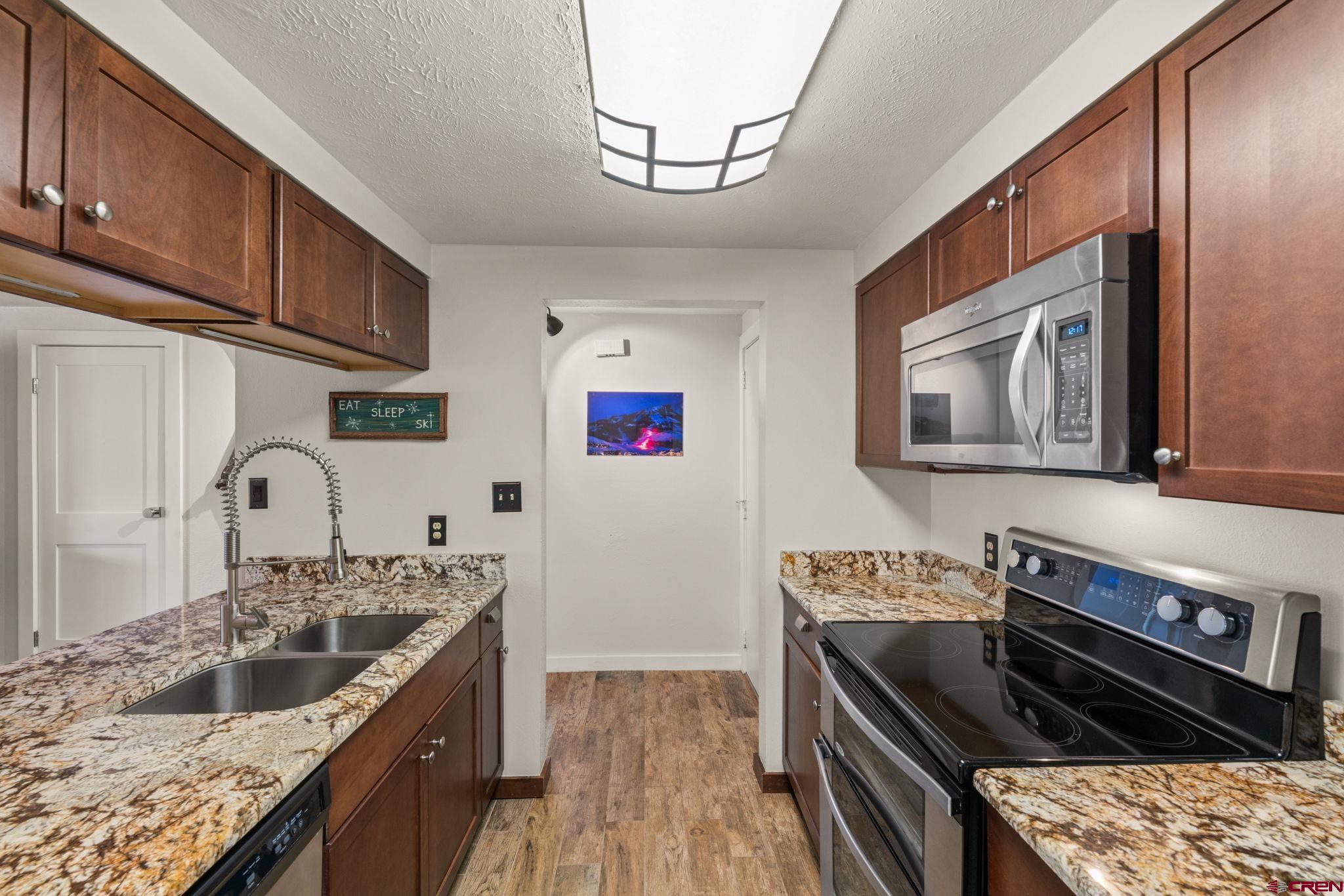 651 Gothic Road, Unit 502 Crested Butte, CO 81225 - Photo 4 of 44 a kitchen with stainless steel appliances granite countertop a stove a sink and a microwave