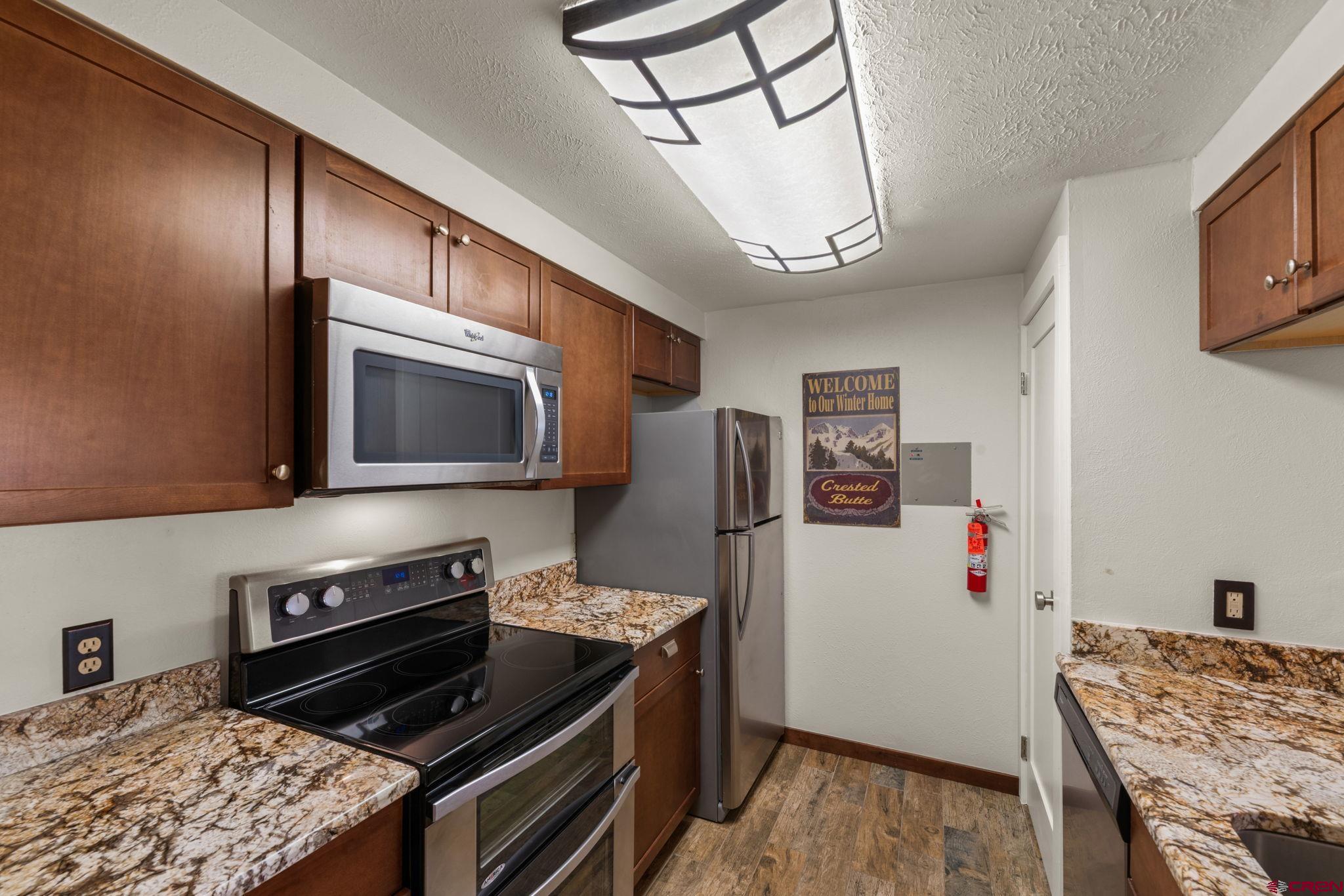 651 Gothic Road, Unit 502 Crested Butte, CO 81225 - Photo 7 of 44 a kitchen with stainless steel appliances granite countertop a stove refrigerator and microwave