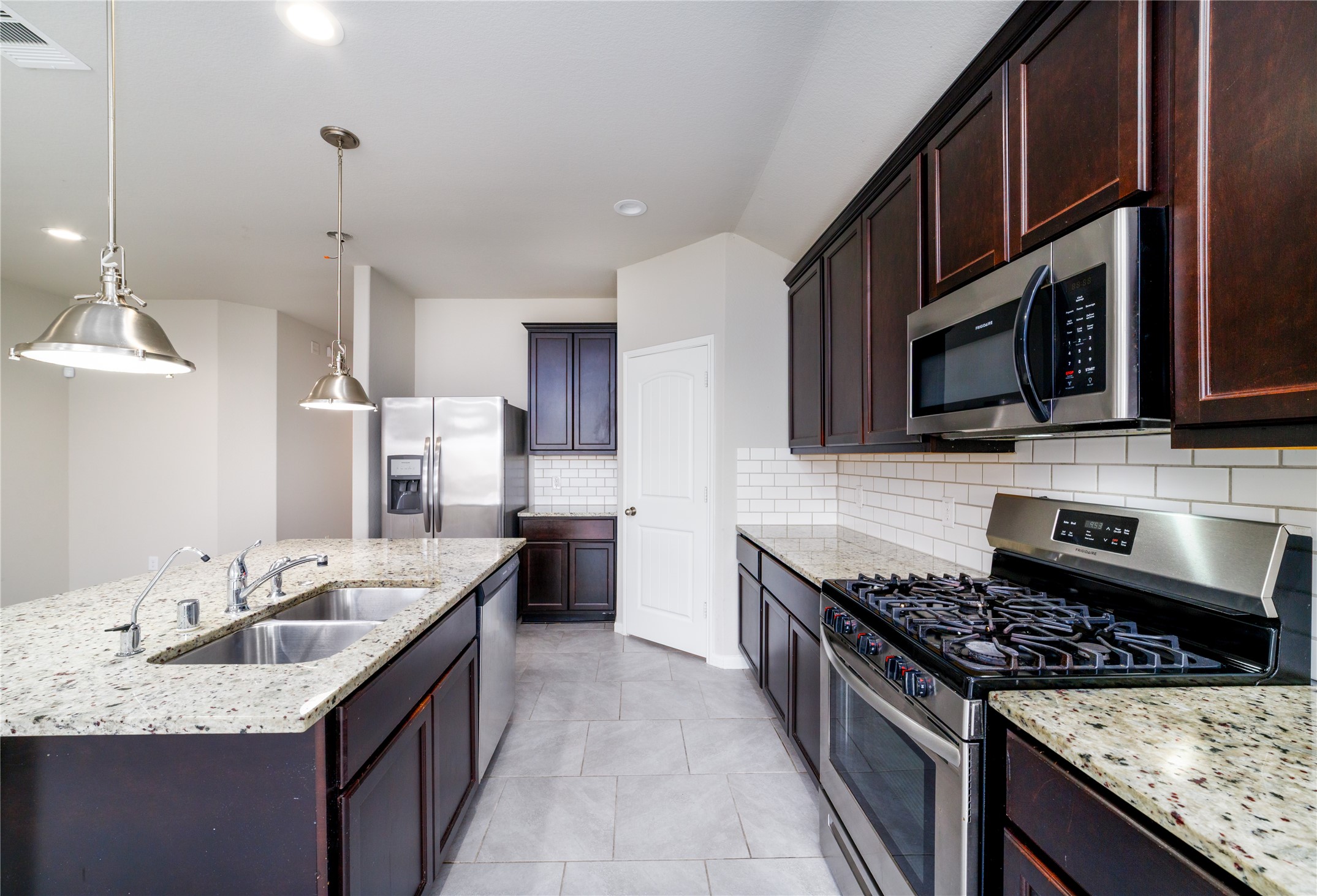 8307 Oakleaf Meadow Court Rosharon, TX 77583 - Photo 12 of 39 a kitchen with stainless steel appliances granite countertop a sink stove and microwave