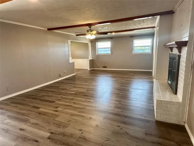 an empty room with wooden floor and a window