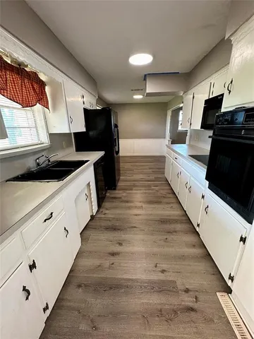 a large kitchen with granite countertop lots of counter top space and stainless steel appliances