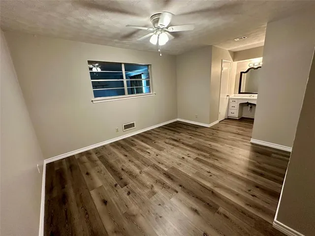 a view of a livingroom with a ceiling fan and wooden floor