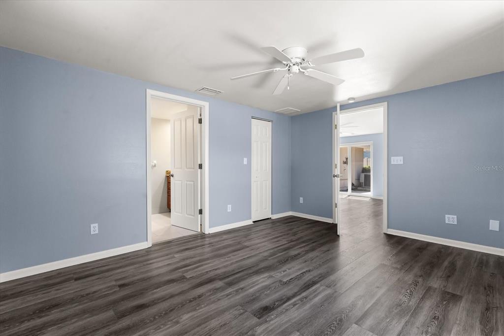 620 Jacaranda Street Dunedin, FL 34698 - Photo 11 of 30 a view of an empty room with wooden floor and a ceiling fan