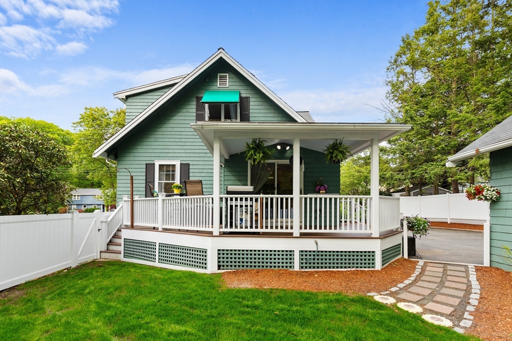 500 Lowell Street Lexington, MA 02420 - Photo 19 of 25 a view of a house with a small deck and a yard with a fountain