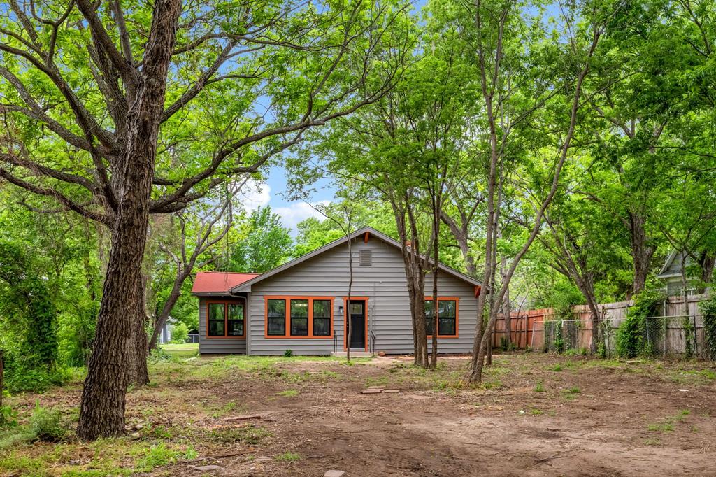 1014 Bolivar Street Denton, TX 76201 - Photo 34 of 36 a wooden house with a big yard and large trees
