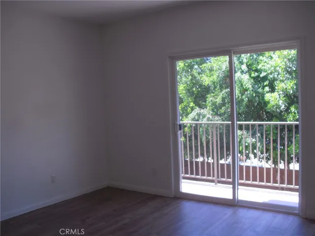 a view of a small space with wooden floor and a window