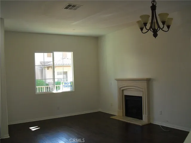 an empty room with a fireplace and wooden floor