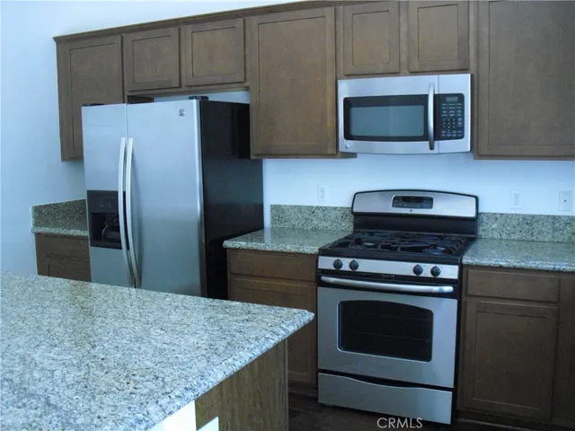 a kitchen with stainless steel appliances wooden cabinets and a stove top oven