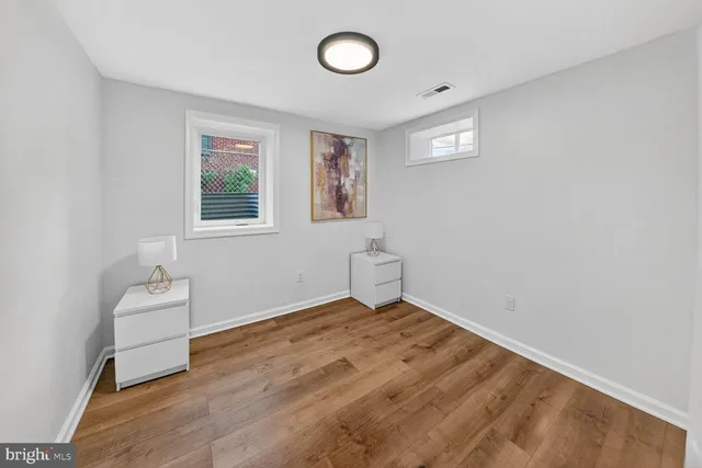 an empty room with a window and wooden floor