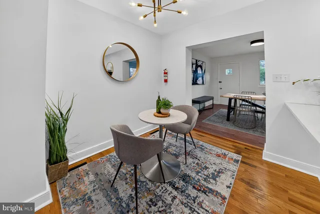 a dining room with wooden floor and a rug