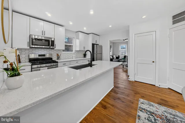 a large white kitchen with stainless steel appliances