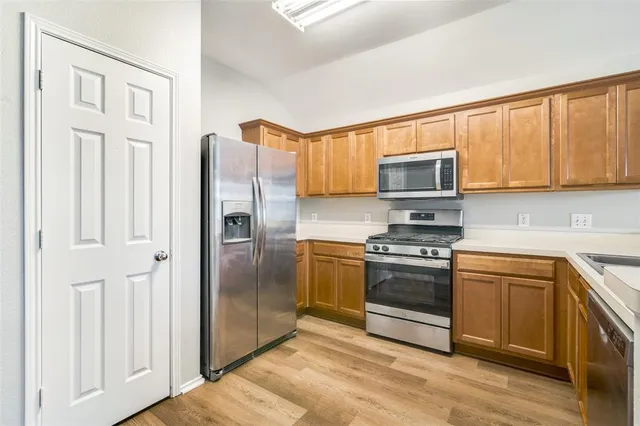 a kitchen with stainless steel appliances granite countertop a stove and a sink