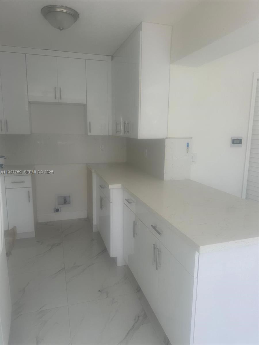 6750 Allen Street Hollywood, FL 33024 - Photo 9 of 79 a kitchen with white cabinets and a sink