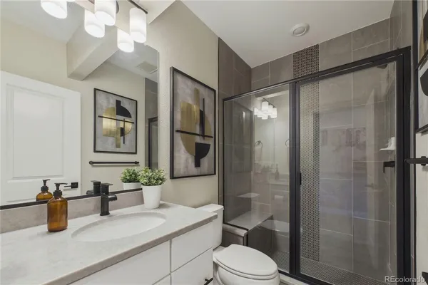 a bathroom with a sink a toilet and shower