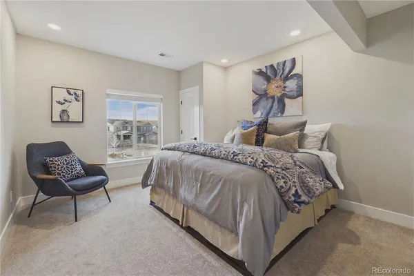 a spacious bedroom with a bed and chair