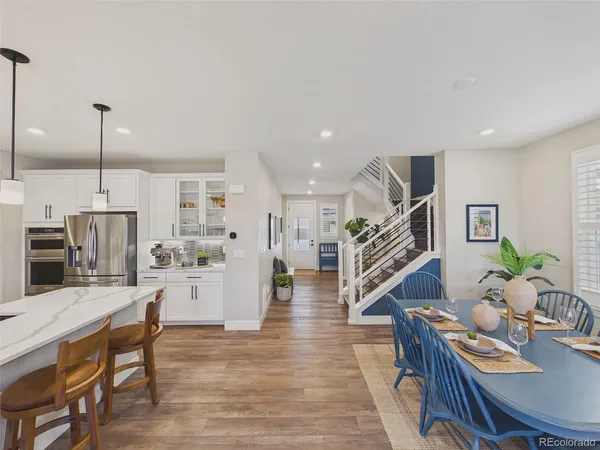 a living room with furniture kitchen view and a wooden floor