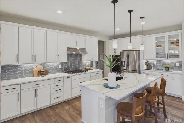 a kitchen with stainless steel appliances kitchen island granite countertop a dining table chairs and white cabinets