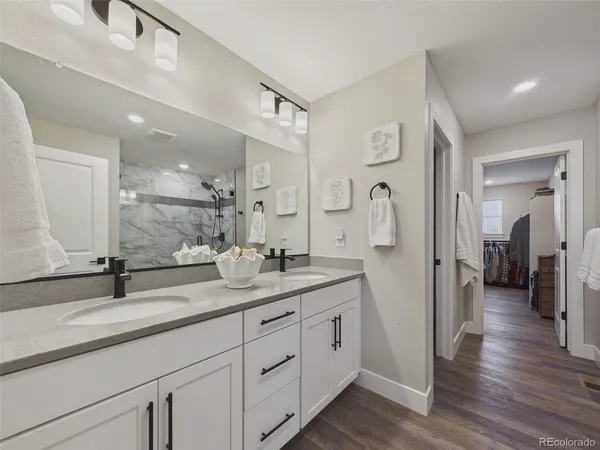a spacious bathroom with a granite countertop sink mirror and shower