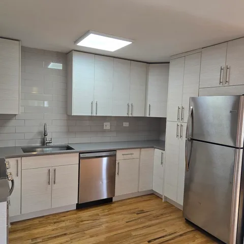 a kitchen with granite countertop a sink stove and refrigerator