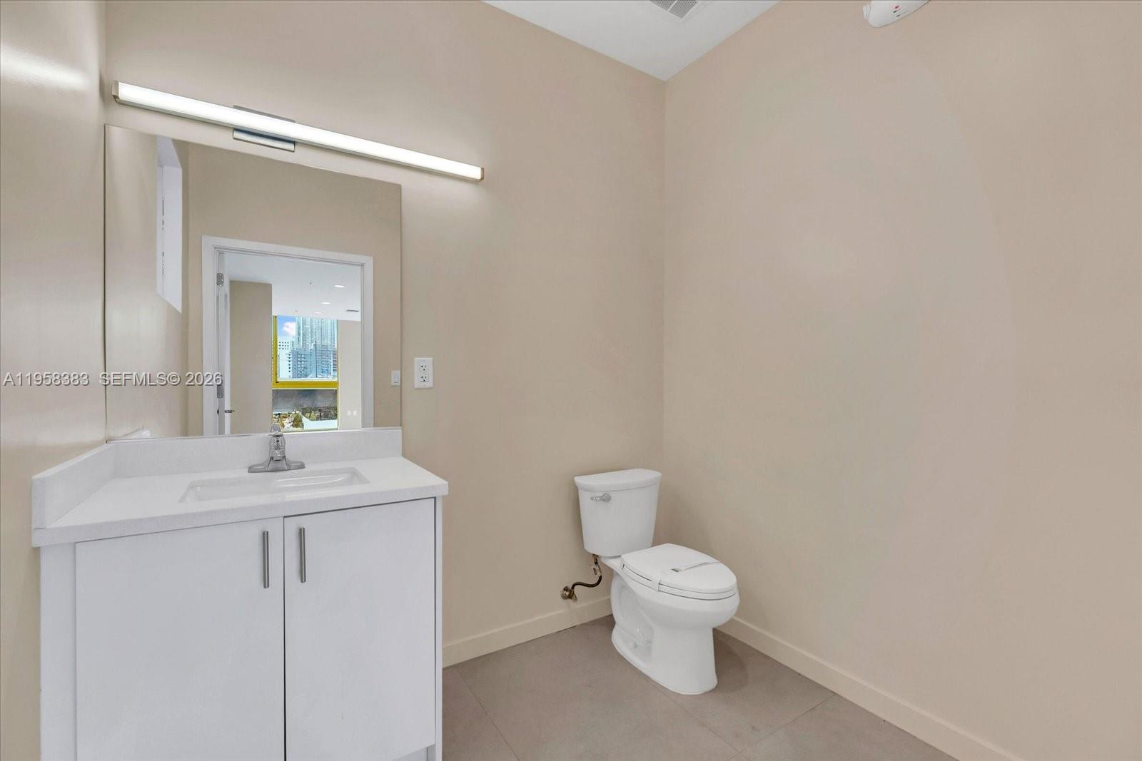 123 Northwest 14th Street, Unit 301 Miami, FL 33136 - Photo 13 of 39 a bathroom with a toilet sink and mirror