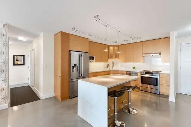 a kitchen with stainless steel appliances granite countertop a sink a stove and a refrigerator