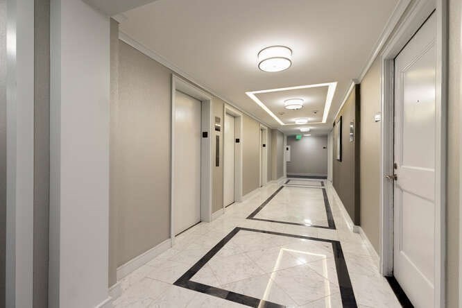 8 Whittier Place, Unit 21E Boston, MA 02114 - Photo 28 of 34 a view of a hallway with a large window and a hallway