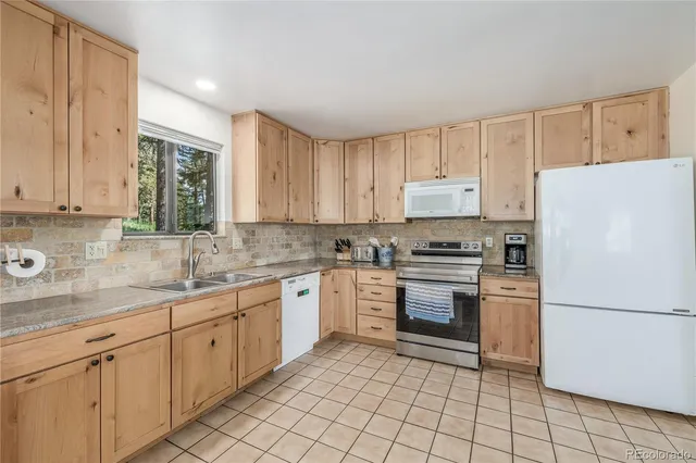 a kitchen with a refrigerator and a stove top oven