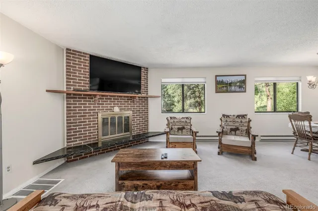 a living room with furniture a flat screen tv and a fireplace