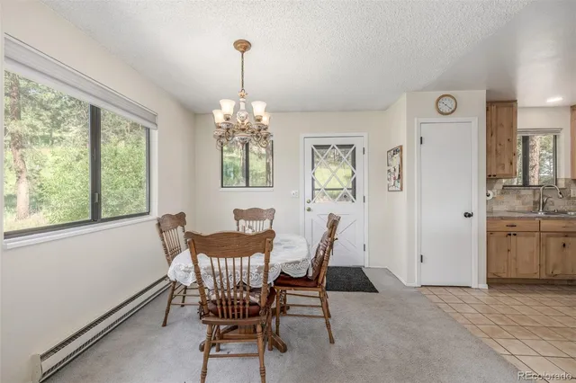 a view of a dining room with furniture a chandelier and wooden floor