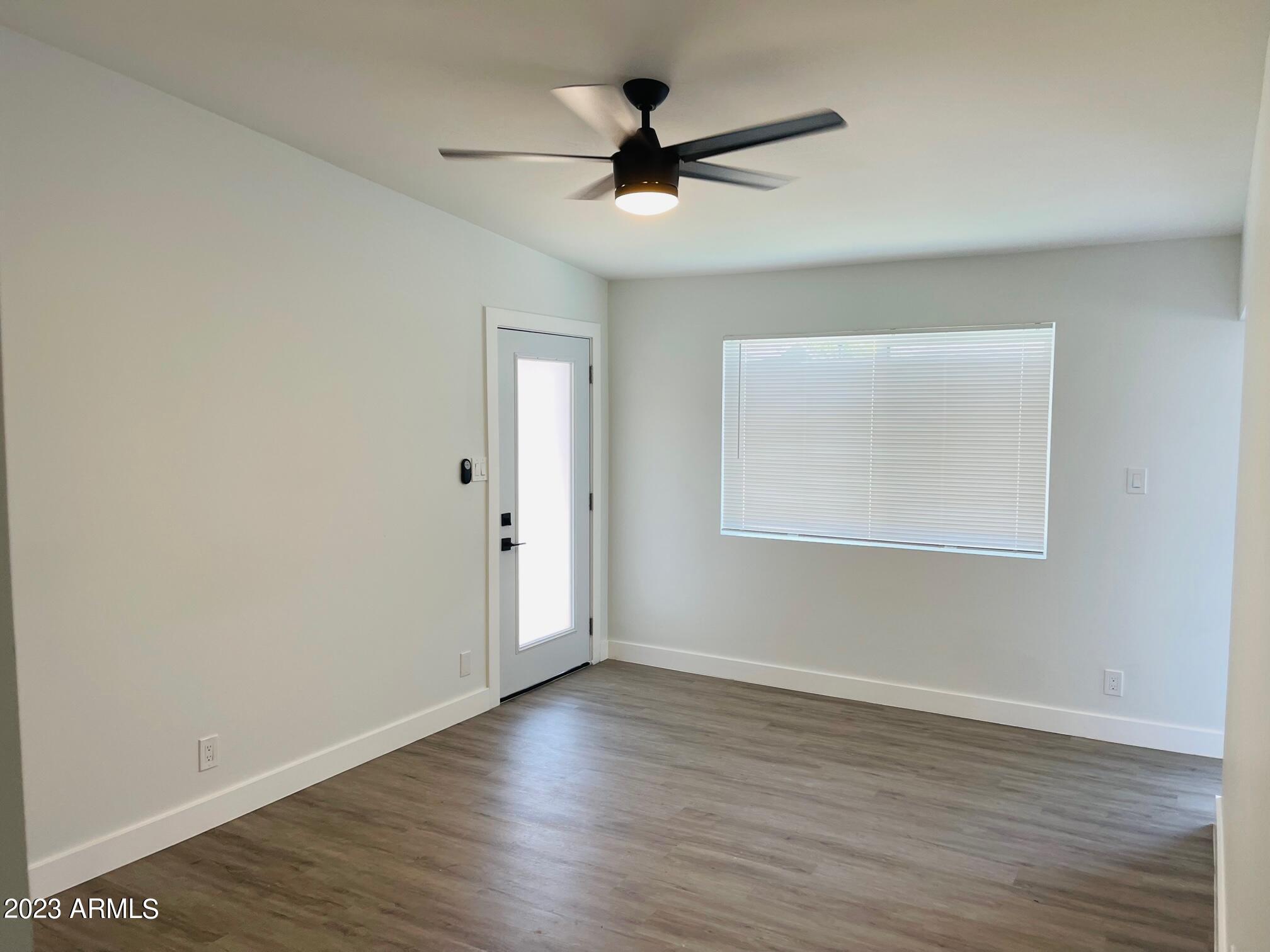 6233 North 13th Place, Unit 1 Phoenix, AZ 85014 - Photo 12 of 20 an empty room with wooden floor and ceiling fan