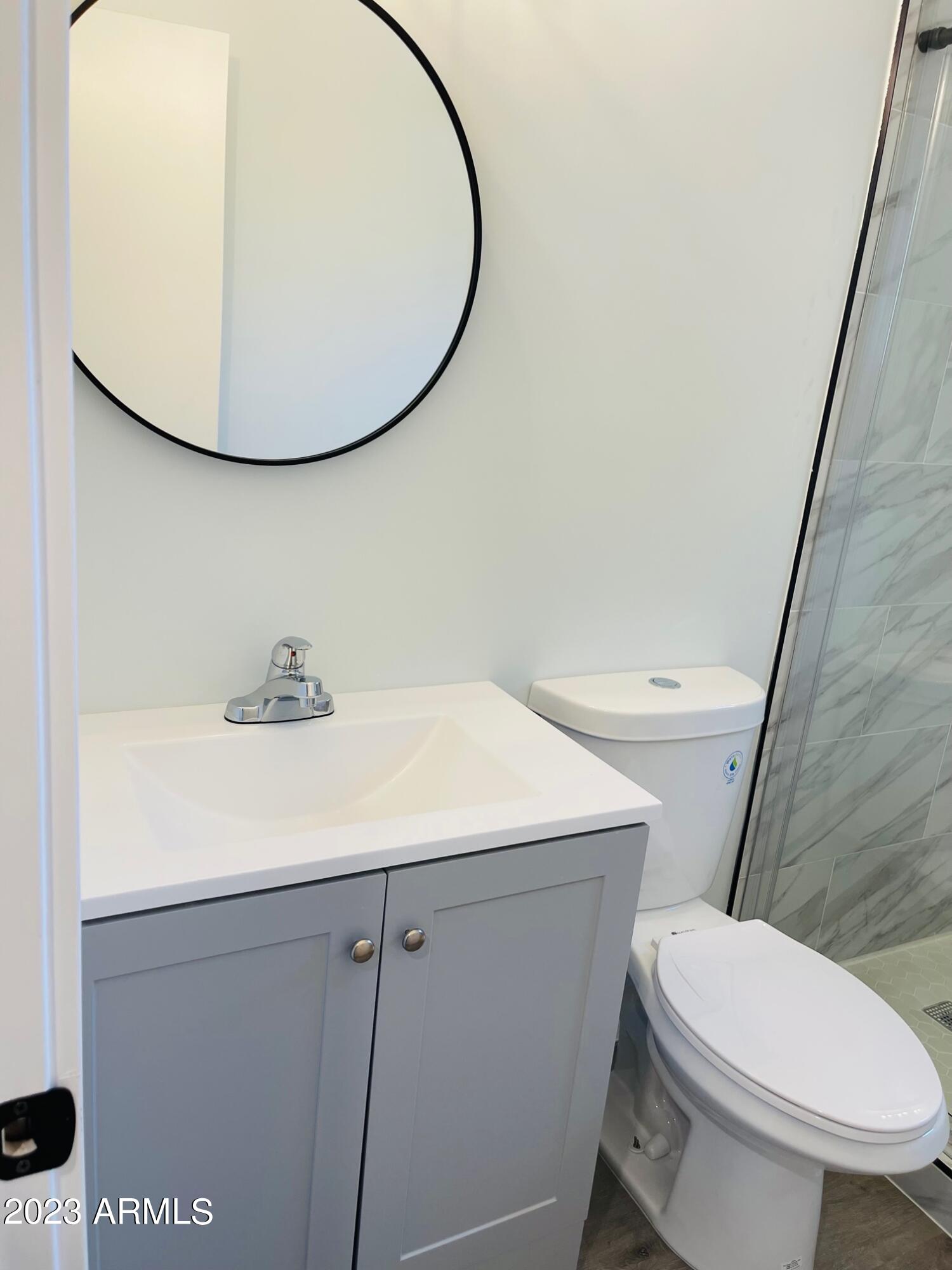 6233 North 13th Place, Unit 1 Phoenix, AZ 85014 - Photo 17 of 20 a bathroom with a sink a toilet and a mirror