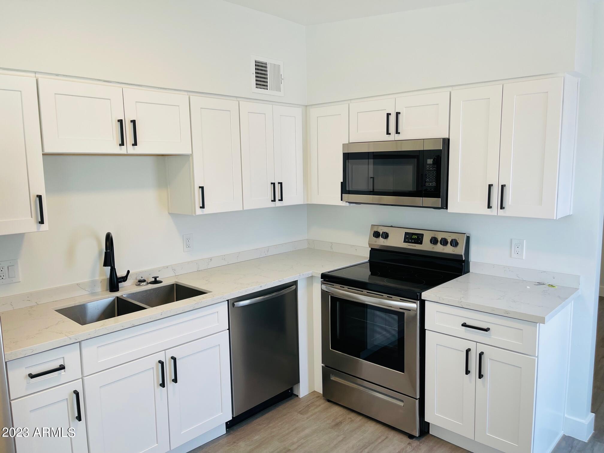 6233 North 13th Place, Unit 1 Phoenix, AZ 85014 - Photo 9 of 20 a kitchen with cabinets stainless steel appliances and a sink