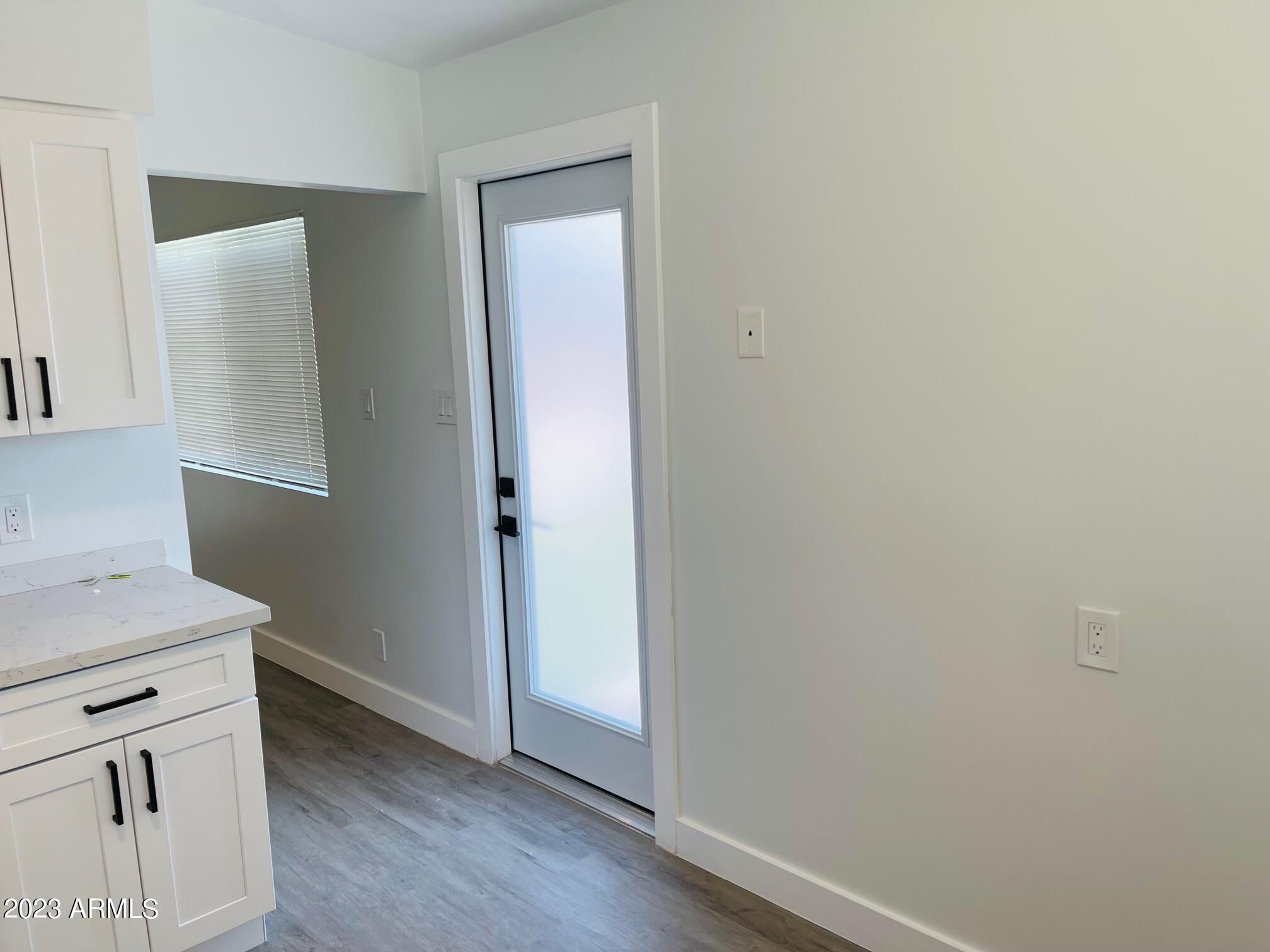 6233 North 13th Place, Unit 1 Phoenix, AZ 85014 - Photo 10 of 20 a view of a kitchen with white cabinets and wooden floor