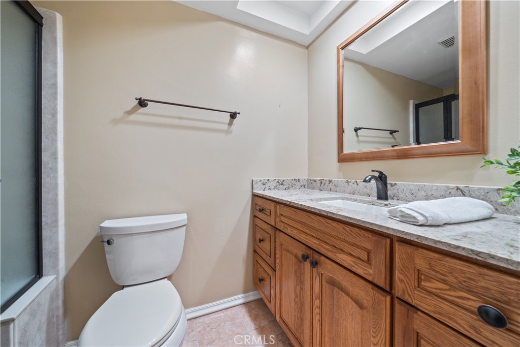5161 Rotherham Circle Westminster, CA 92683 - Photo 14 of 24 a bathroom with a granite countertop toilet sink and mirror