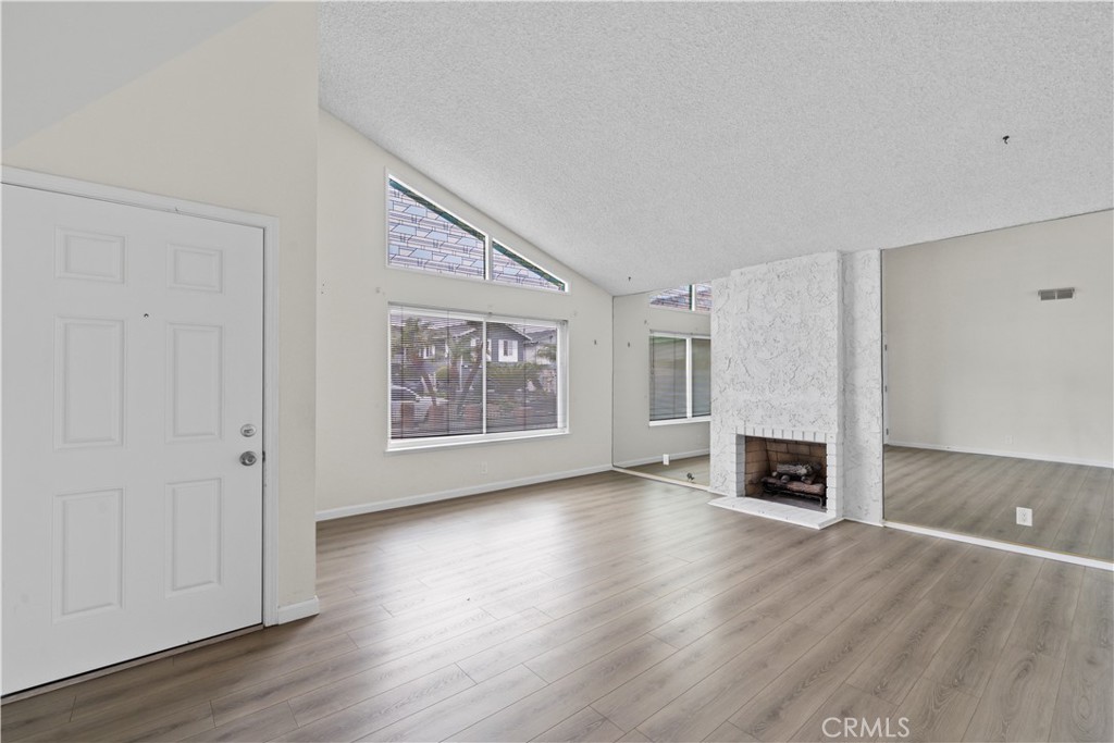 5161 Rotherham Circle Westminster, CA 92683 - Photo 2 of 24 an empty room with wooden floor fireplace and windows