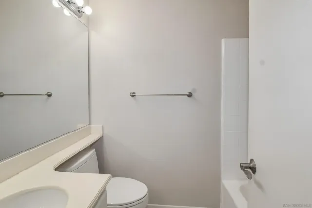 a white toilet sitting next to a shower