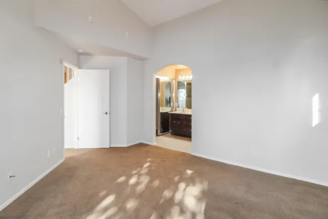 an empty room with a fireplace and mirror