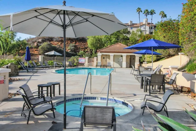 a view of a patio with chairs under an umbrella