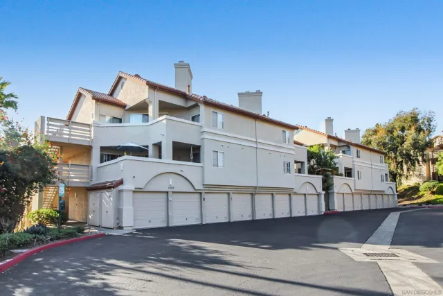 a view of a white building among the street and trees