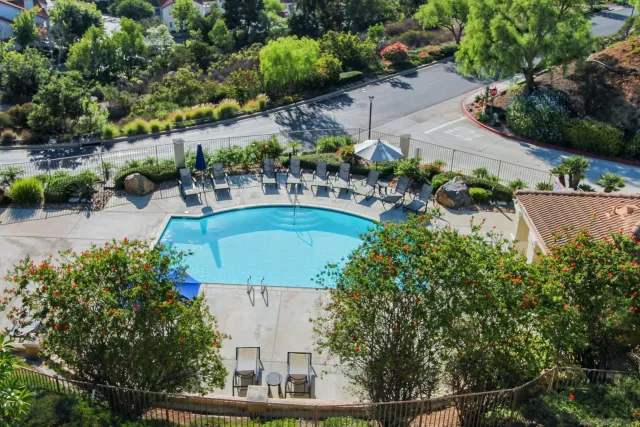 an aerial view of a house with swimming pool and outdoor seating